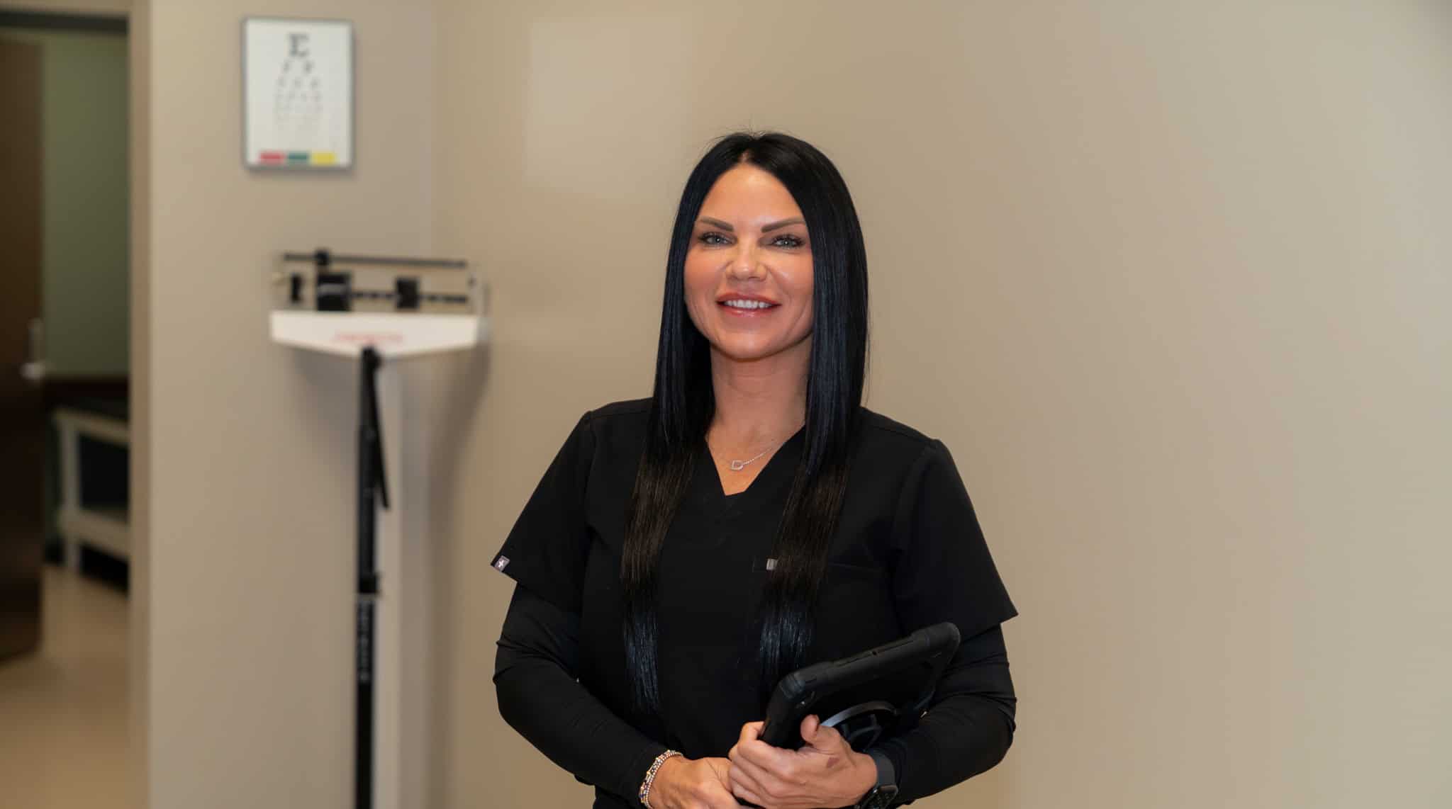 Healthy healthcare professional holding a digital tablet at Gulf Coast Occupational Medicine clinic.